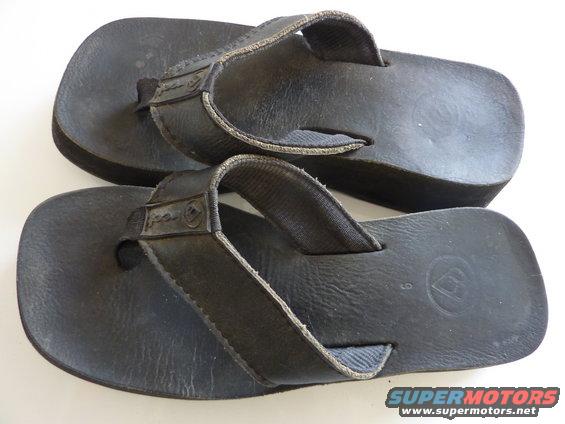 Pair of black flip-flops with straps and soles showing some wear. A size 9 is visible on one sole