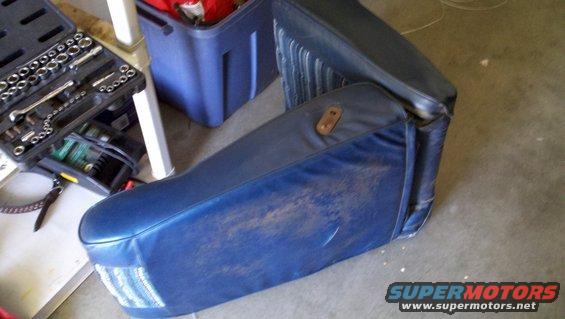 Blue car seat with brown stains and a toolbox nearby