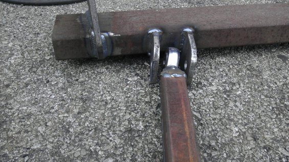 Close-up of a welded metal bracket with square tubing attached