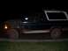 1992 Ford Bronco - Muddy 1992 Ford Bronco seen from the side at night.