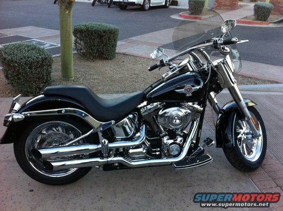 Black Harley-Davidson motorcycle side view with chrome accents and windshield