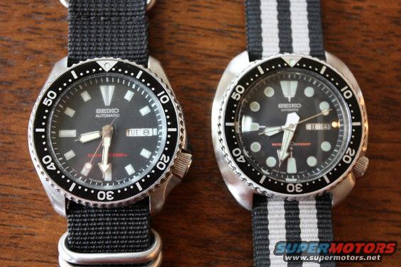 Two Seiko dive watches with black dials and rotating bezels, one on a black nylon strap, the other on a black and white striped strap
