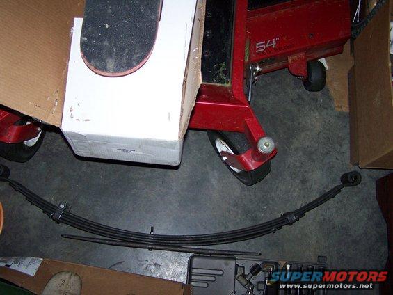 Leaf spring and part of a red lawnmower deck with '54"' visible