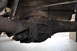 1986 Ford Bronco - Underside view of a vehicle's rear axle assembly, showing signs of wear and rust.
