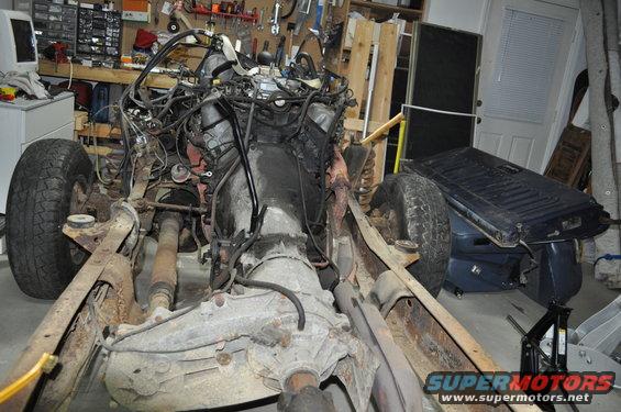 Disassembled vehicle chassis with engine and transmission exposed