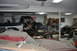 1986 Ford Bronco - A disassembled truck sits in a garage, partially covered by other vehicles and project parts.