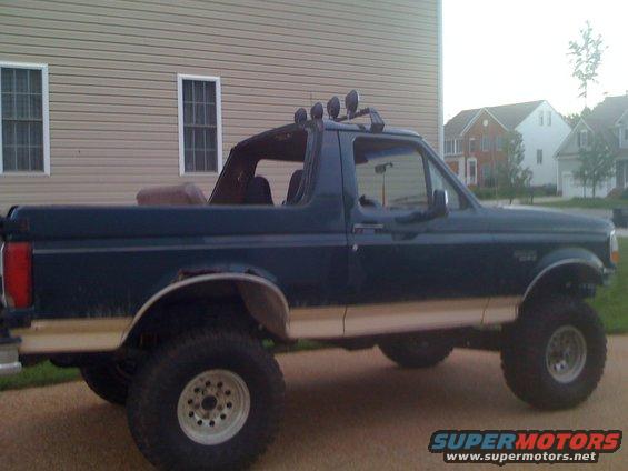 1992 Ford Bronco, dark green with tan trim, lifted with off-road lights on roof