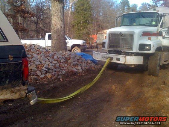 Ford Bronco being towed by a cement truck with a tow strap