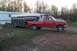 1987 Ford F-250 - A red 1987 Ford F-250 pickup truck is hitched to a trailer in a rural setting.