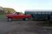 1987 Ford F-250 - A red 1987 Ford F-250 pickup truck is seen from the side, towing a large horse trailer.