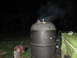 1970 Mercury Cougar - Smoker is active and producing smoke at night, with a tarped area and device nearby.
