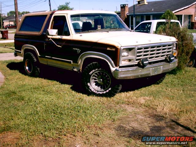 1980 Ford Bronco with two-tone paint and aftermarket wheels parked on grass