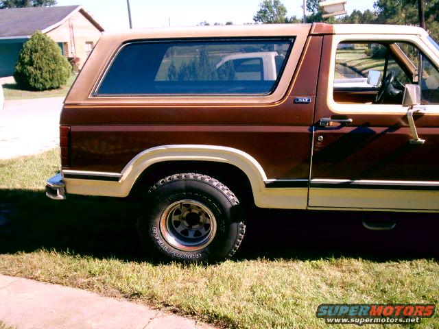 Side view of a brown and tan Ford Bronco with a removable top