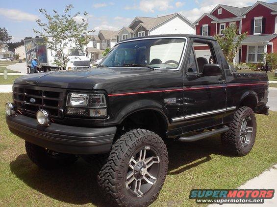 1992 Ford Bronco, black with red pinstripes, lifted with aftermarket wheels