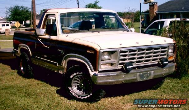 1980s Ford F-Series pickup truck, two-tone paint, aftermarket wheels and lights