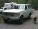 1992 Ford Bronco - A 1992 Ford Bronco is parked outside with a pickup truck and camper trailer in the background.