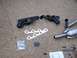 1992 Ford Bronco - Exhaust manifolds, catalytic converter, gaskets, and hardware are laid out on a concrete surface.