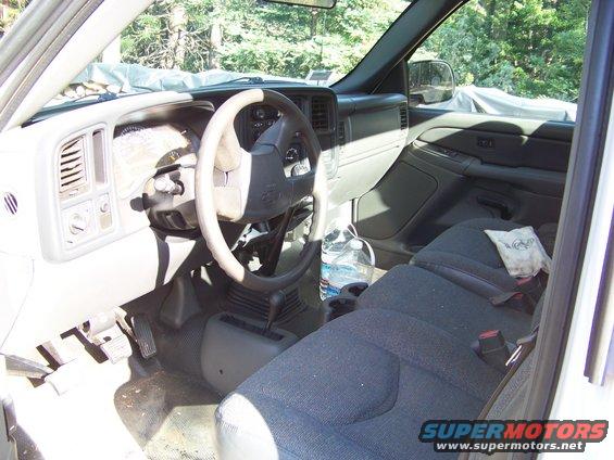 Interior view of a truck cab showing seats, dashboard, and steering wheel