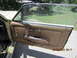 1968 Mercury Cougar - Close-up of a car's interior door panel, showing the brown upholstery and chrome hardware.
