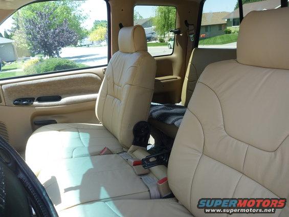 Interior shot of a truck with tan leather seats and a blanket on the back seat