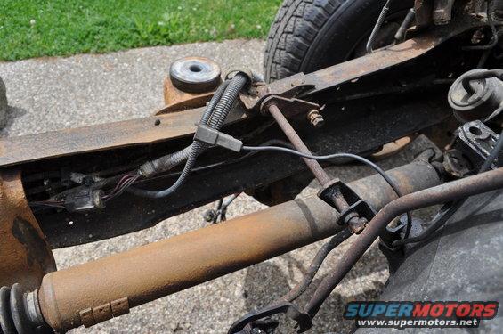 Frame and suspension parts of a vehicle, showing rust and wiring