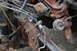 1986 Ford Bronco - This image shows a section of a vehicle's frame with various mechanical components attached, including brake lines and part of the engine.