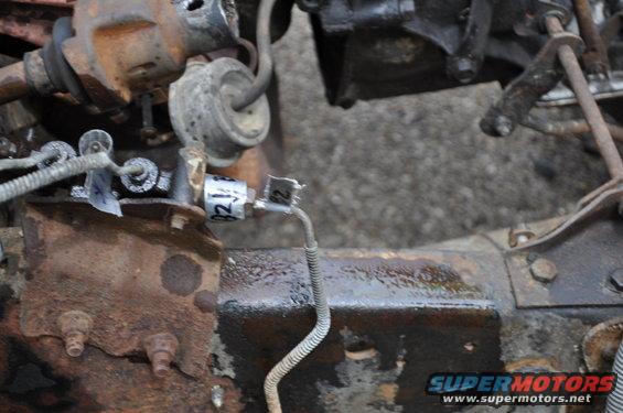 Rusty vehicle chassis with brake line and electrical components. Label reads 'B2'