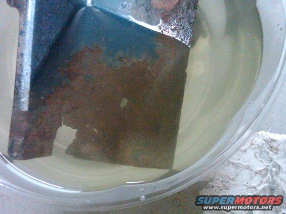 Rusted metal part soaking in liquid
