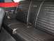 1964 Ford Fairlane - The interior of a 1964 Ford Fairlane features a black vinyl bench seat with distinctive white piping and chrome accents.