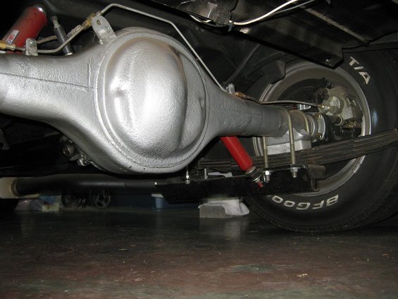 Rear axle assembly with red shock absorbers and leaf springs. BFGoodrich tire visible