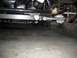 1964 Ford Fairlane - Close-up of the front suspension and steering rack of a vehicle, with a red dolly visible in the background.