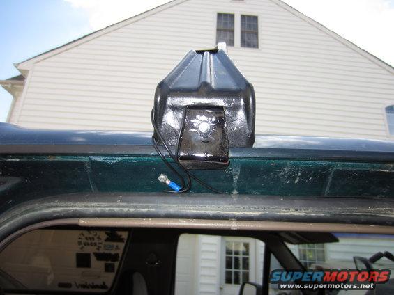 Black light bar mount attached to the roof of a dark green vehicle