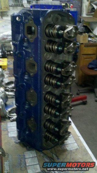 Blue engine cylinder head with visible valves and springs