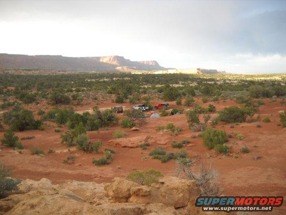 Desert landscape with several vehicles and tents set up