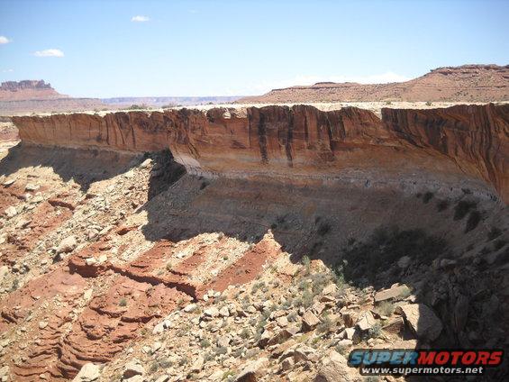 Desert landscape with layered cliffs and mesas under a blue sky