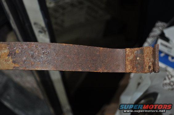 Rusted metal strap with visible text 'SUPERMOTORS'