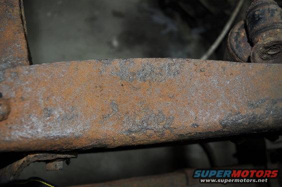 Heavily rusted metal frame component, possibly from a vehicle undercarriage