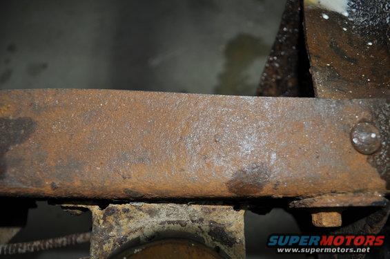Heavily rusted metal frame section with visible bolt