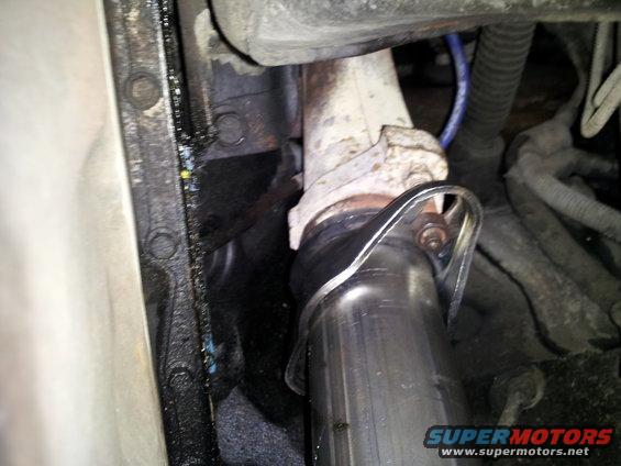 Exhaust pipe connection to manifold with visible text 'SUPERMOTORS'