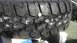 1989 Ford Bronco - A close-up view of an off-road tire, showing its aggressive tread pattern and a coin placed on top.