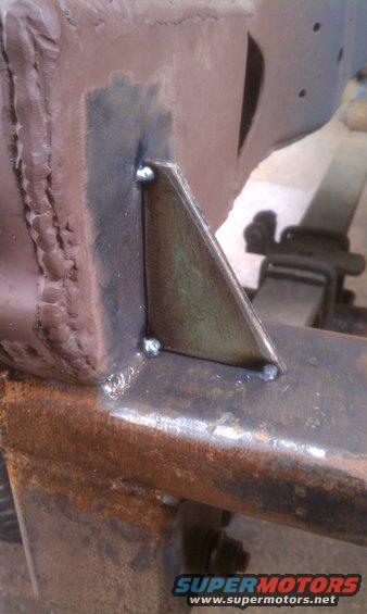Welded metal bracket on rusty vehicle frame