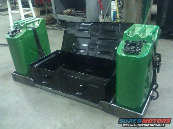 Green jerry cans and black toolbox on metal frame