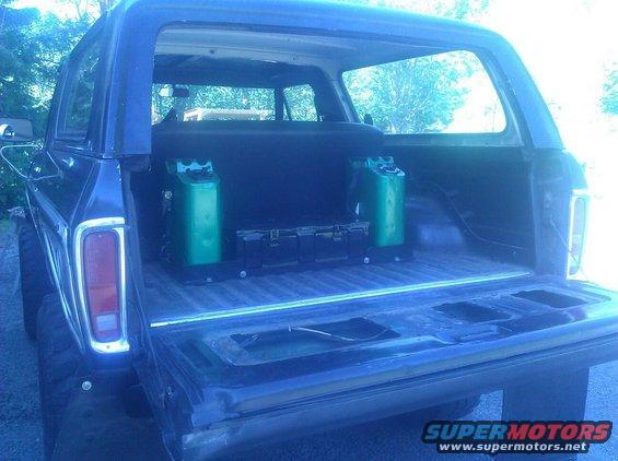 1978 Ford Bronco rear cargo area with two green fuel cans and black storage boxes