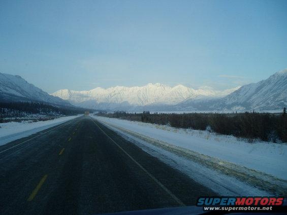 Snowy highway with mountains in the distance