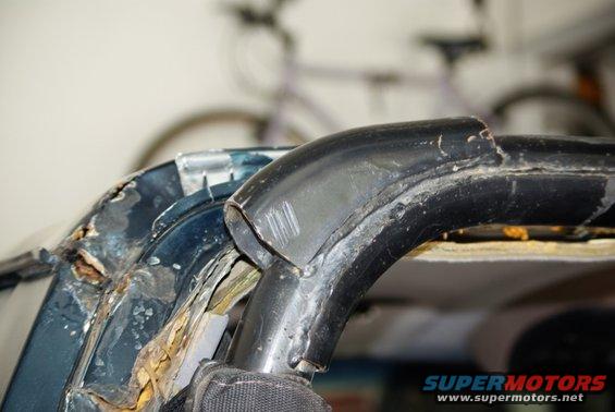Close-up of a rusted vehicle roll bar and damaged frame section