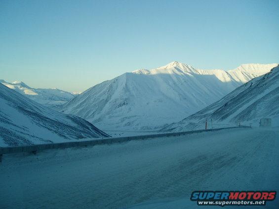Truck driving on a snowy road through mountains