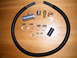 2004 Ford Crown Victoria - A collection of automotive parts, including flexible tubing and various metal connectors and clamps, laid out on a wooden surface.