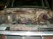 1983 Ford Bronco - The engine compartment of an older vehicle, showing the engine and various hoses and wires.