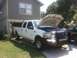 2004 Ford F-350 - White 2004 Ford F-350 crew cab pickup truck with its hood open, parked in a driveway.