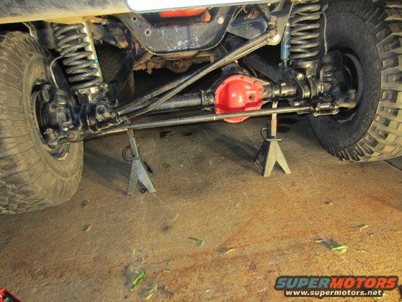 Undercarriage of a 1992 Ford Bronco on jack stands, showing suspension and differential